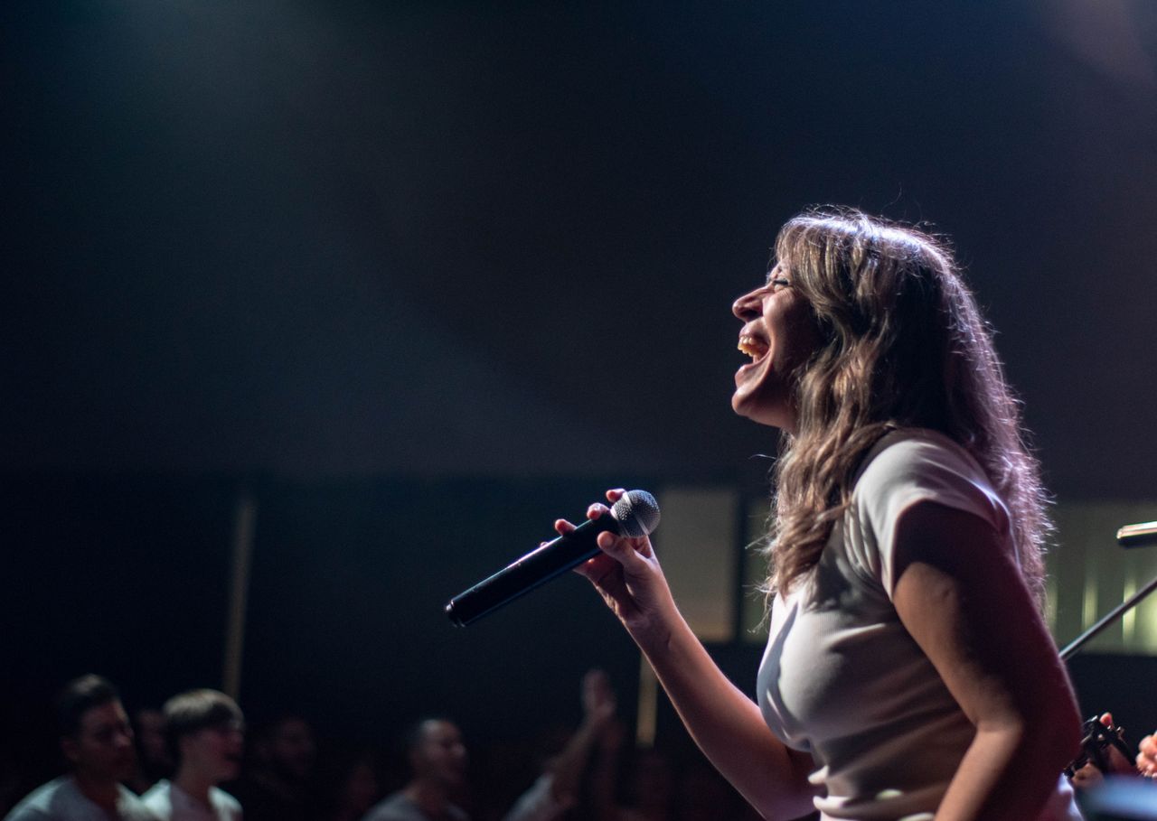 Crafting Captivating Headlines: Your awesome post title goes here Charismatic female singer performing passionately on stage during a live concert.