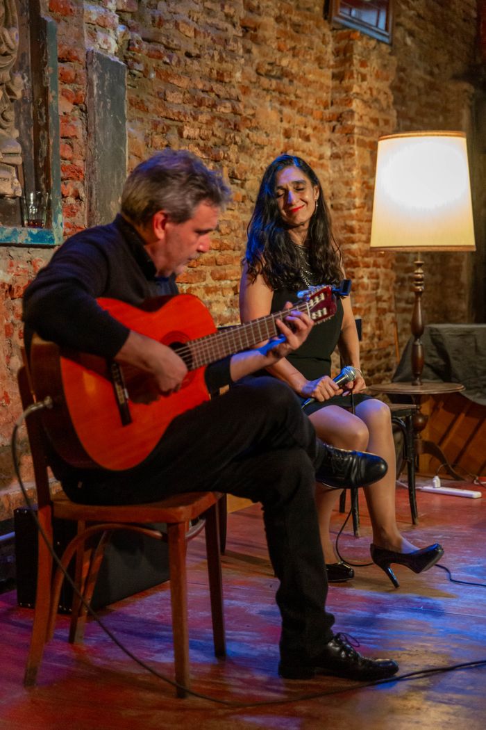About A guitarist performs live in a cozy, rustic setting with warm lighting in Mar del Plata.