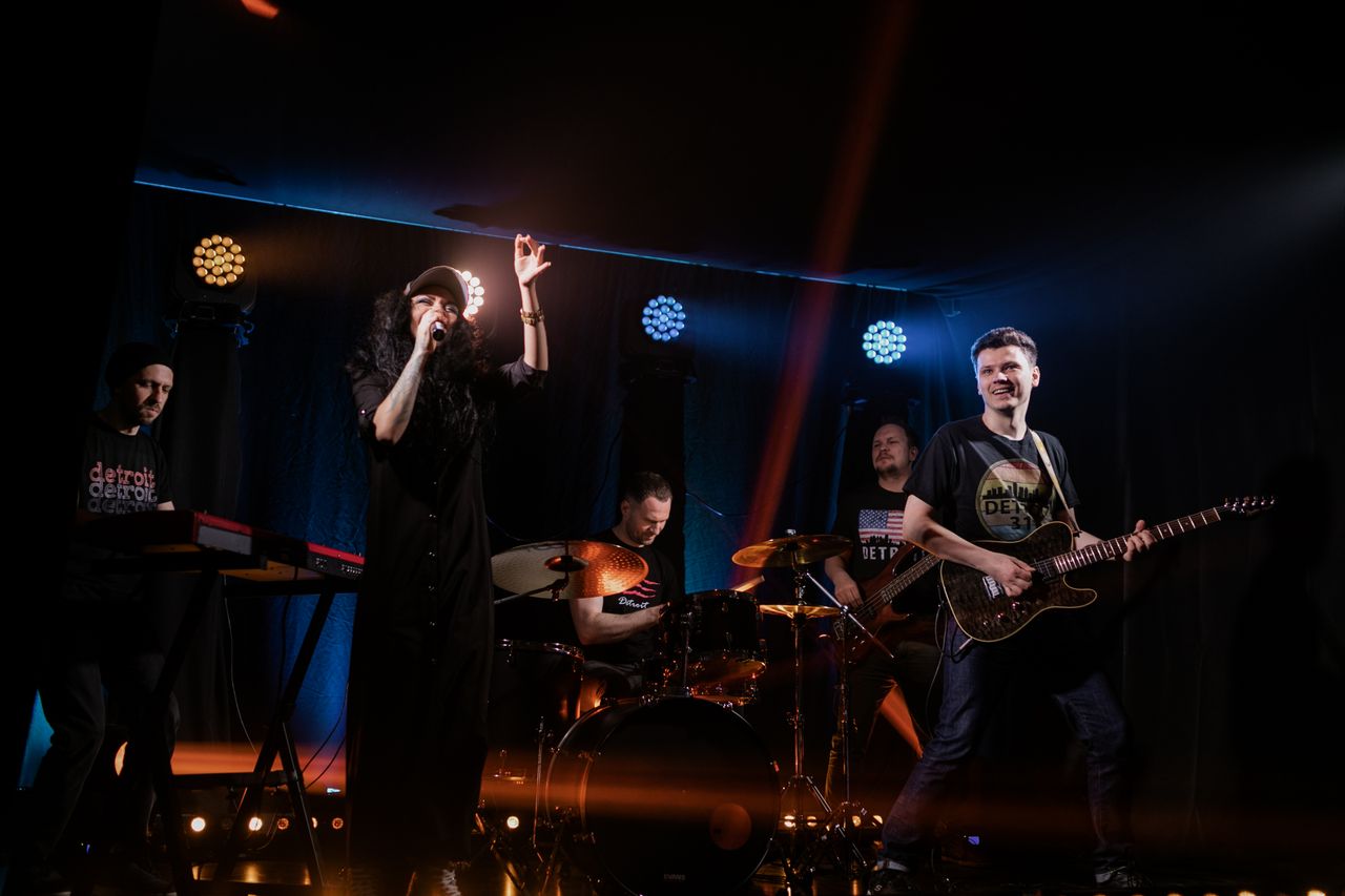 Services Dynamic live music performance featuring a rock band with singer and instruments on stage.