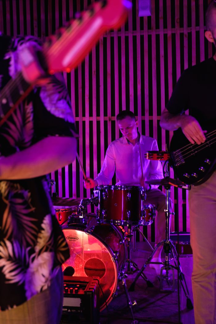 Services Vibrant live band performance featuring a drummer in an indoor setting with colorful lighting.